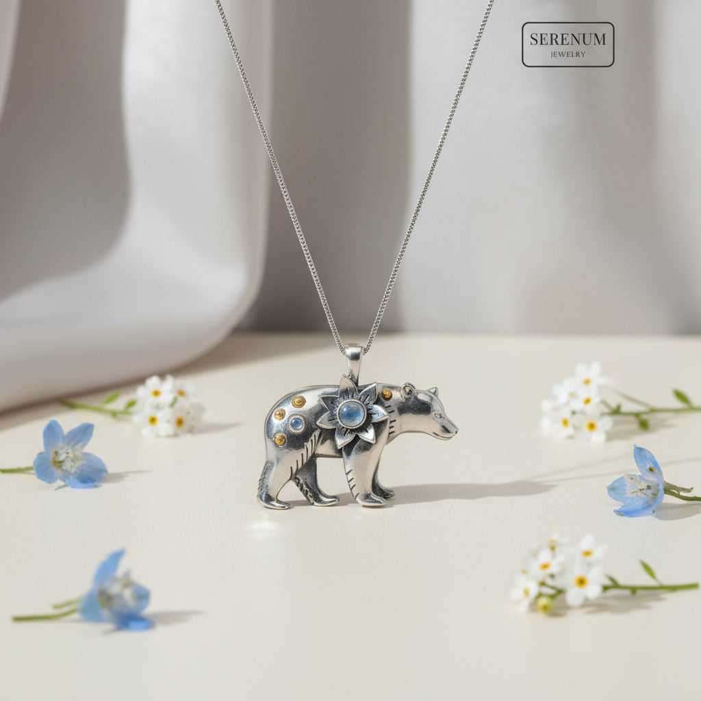 Silver bear pendant with gemstones on a white background, branded 'Serenum'.